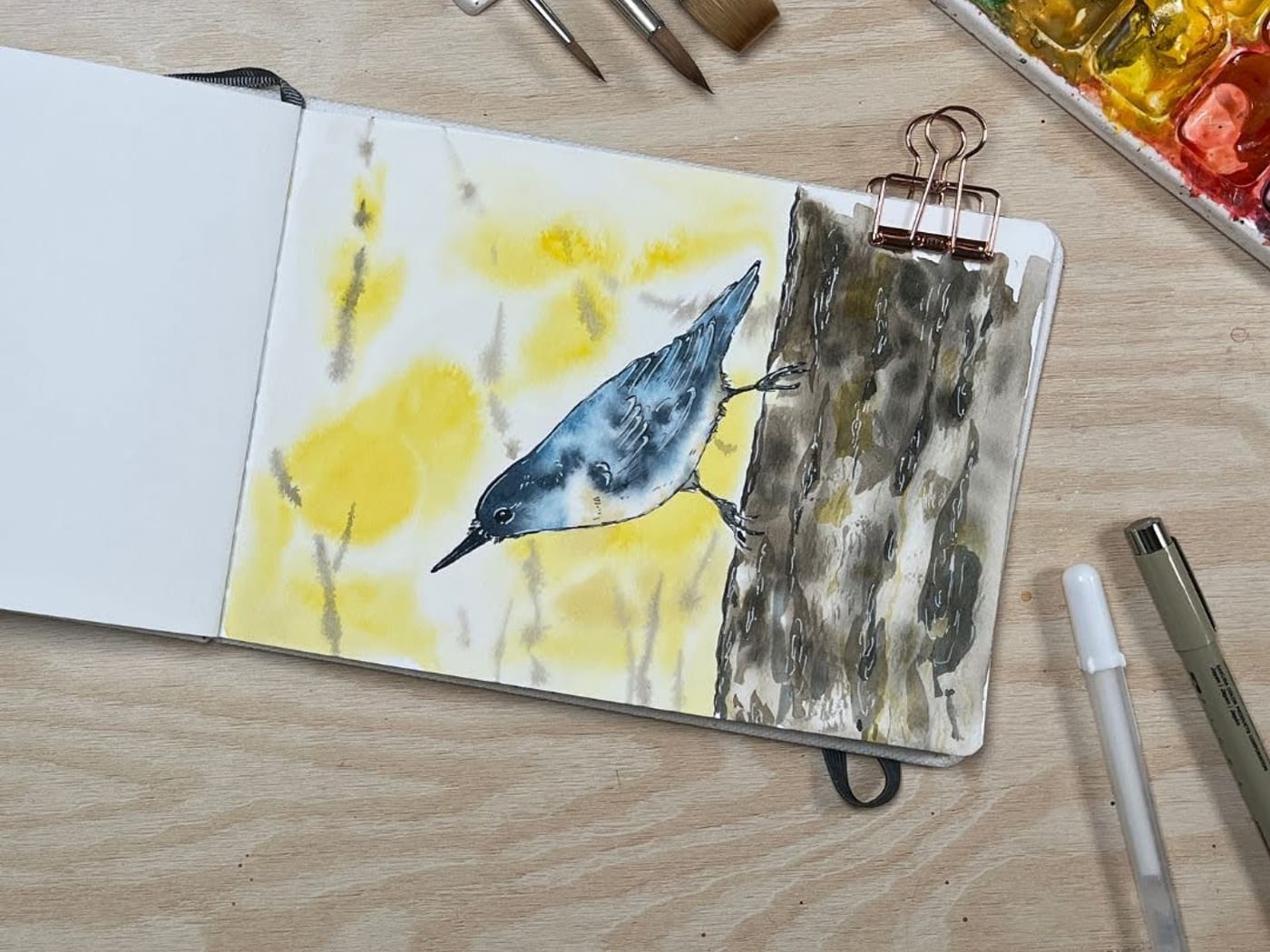 Ink and wash painting of a nuthatch climbing down a tree trunk
