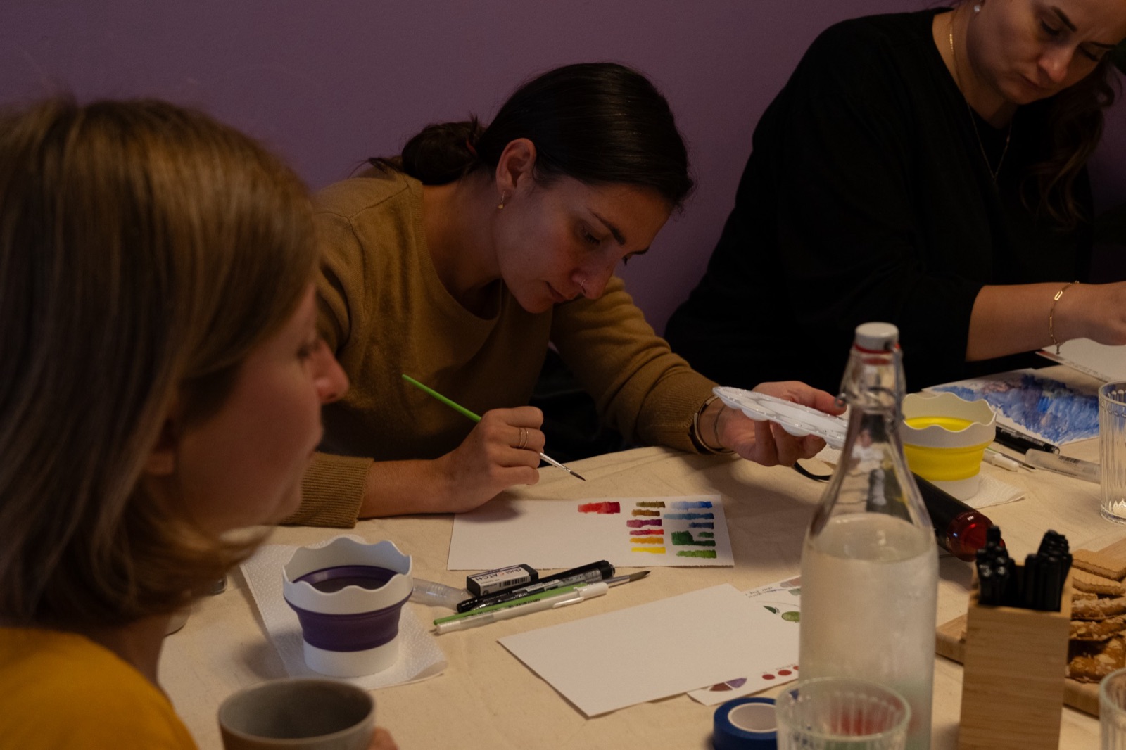 A woman painting her first watercolour swatches at a workshop in Delft