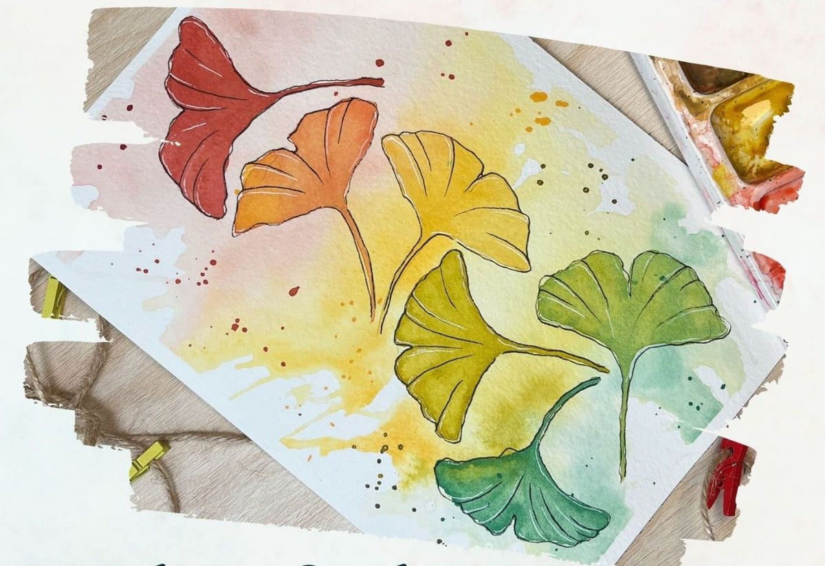 Ginkgo leaves painted in red, orange, yellow and green over a rainbow watercolor wash
